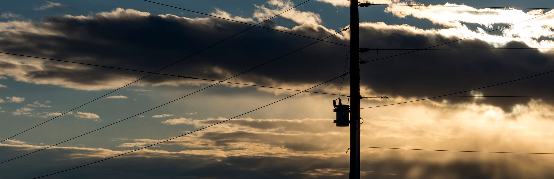 Powerlines in front of a cloudy sunset